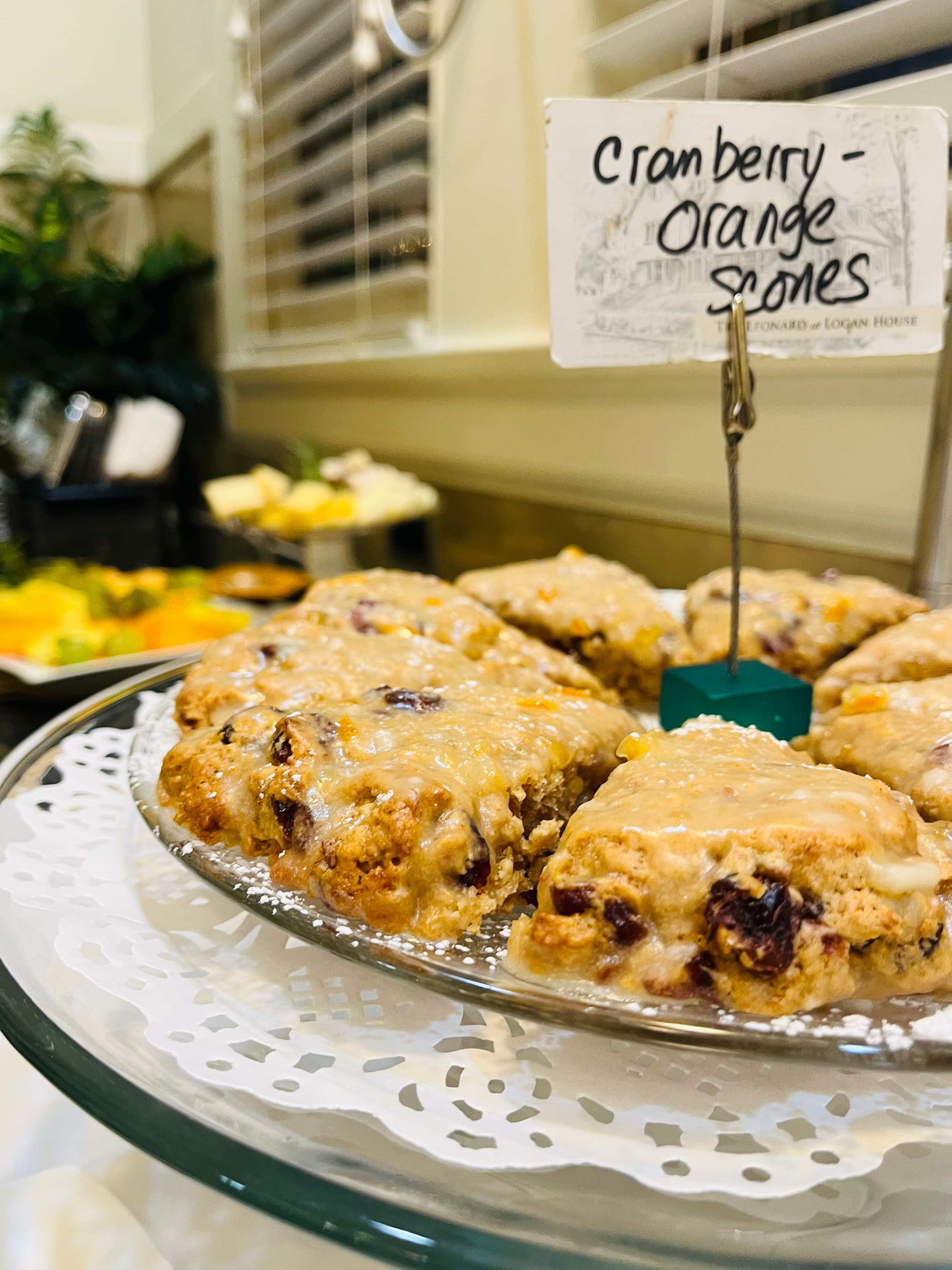 A plate of cranberry-orange scones with a sign indicating their flavor.
