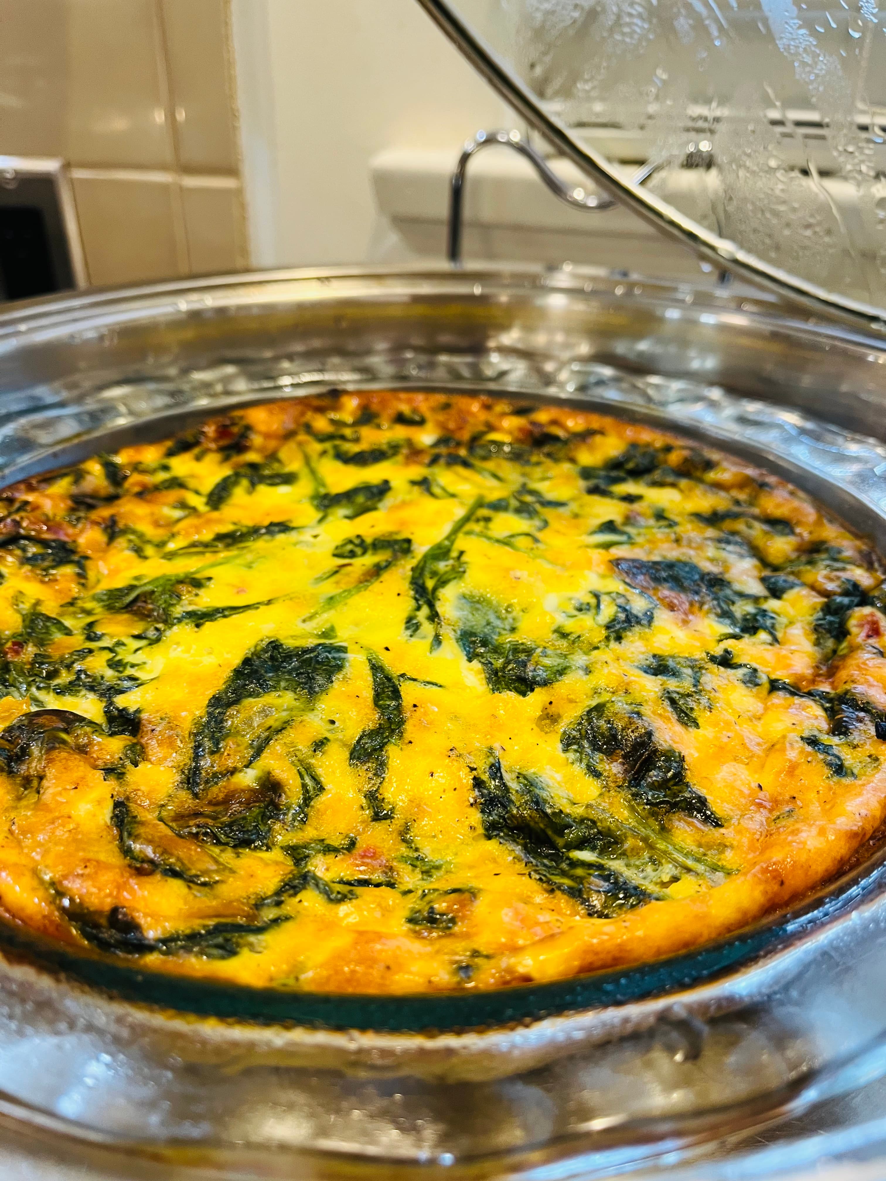 A baked spinach frittata in a glass dish.